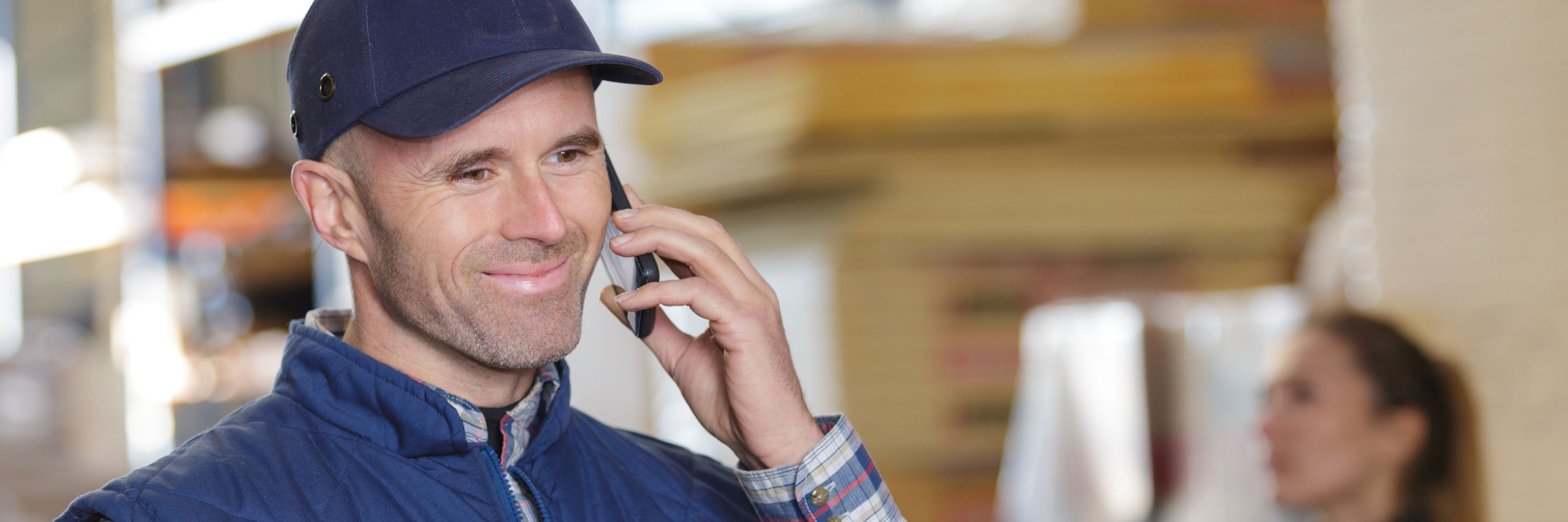 Mand på et lager der taler i mobiltelefon