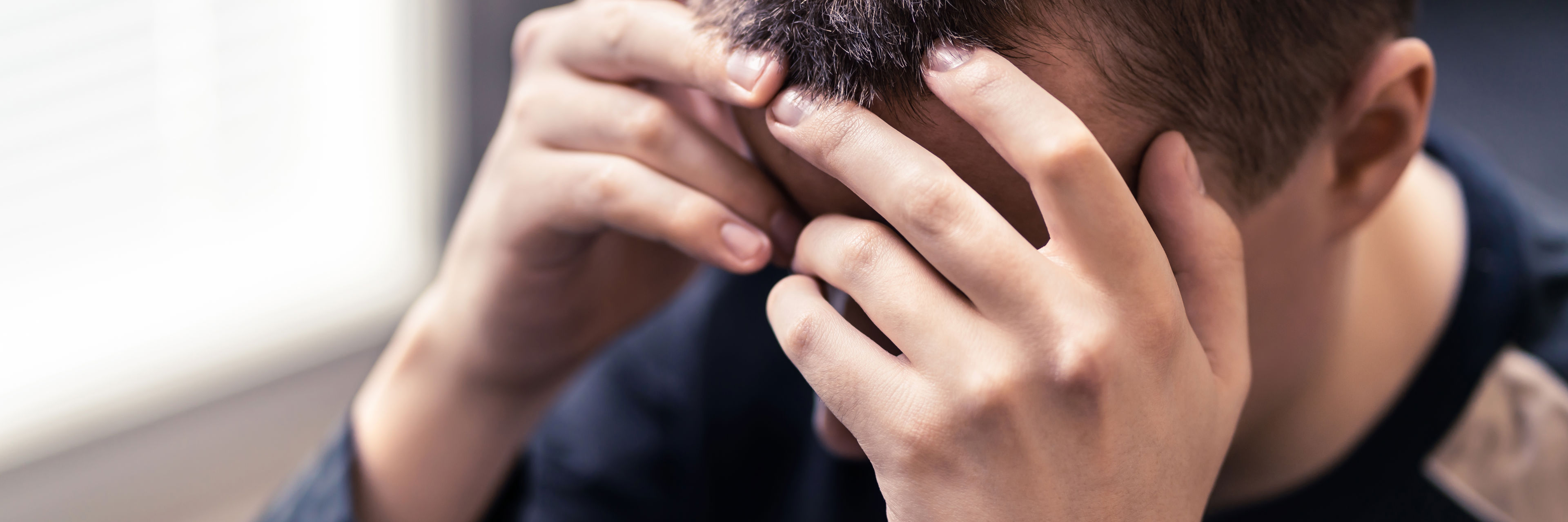 Person der støtter hænderne i hovedet