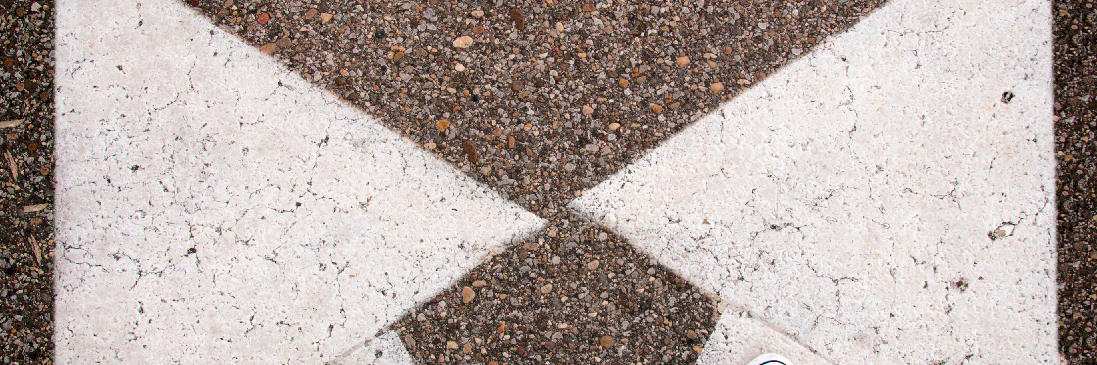 Pile på asfalt peger i to retninger ny adfærd i livet nye valg ny retning ny kurs