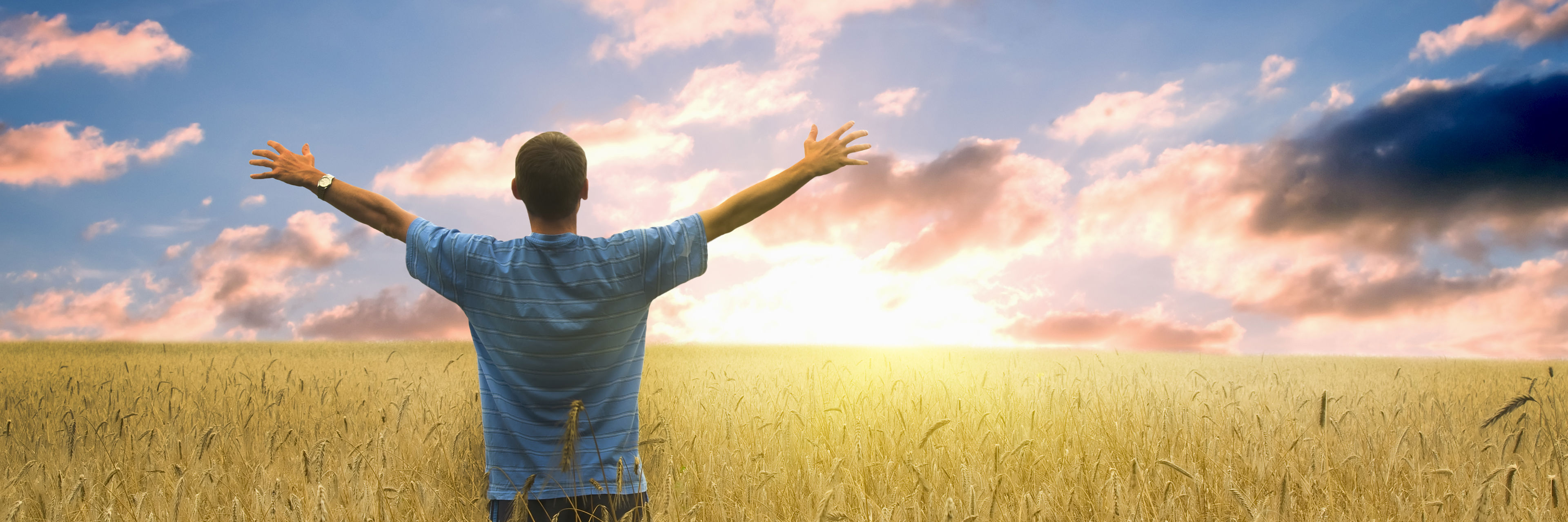 Mand der ser på horisonten med arme ude