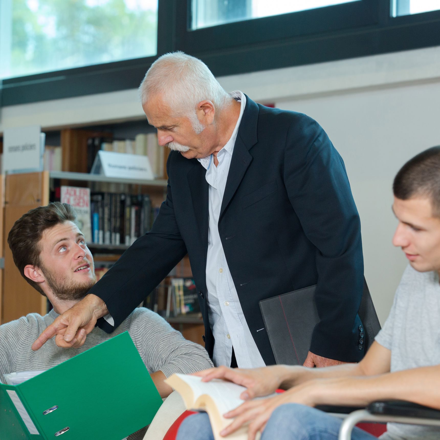 Tre mænd der kigger i bøger