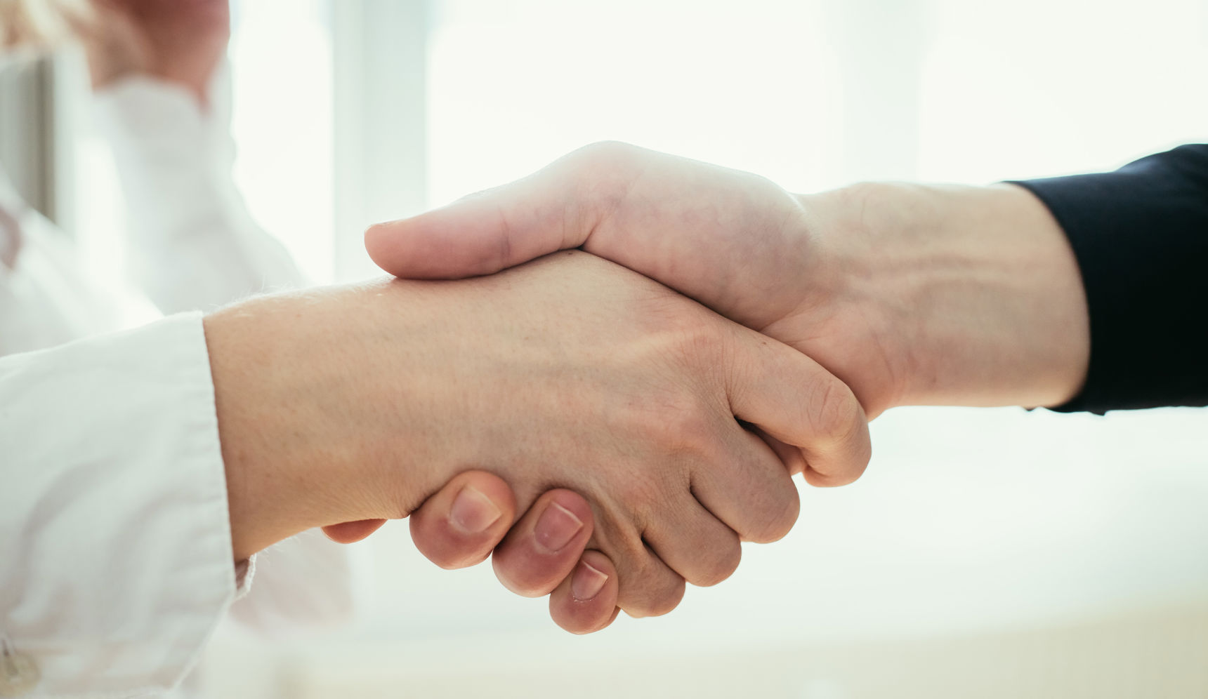 Håndtryk mellem to mennesker