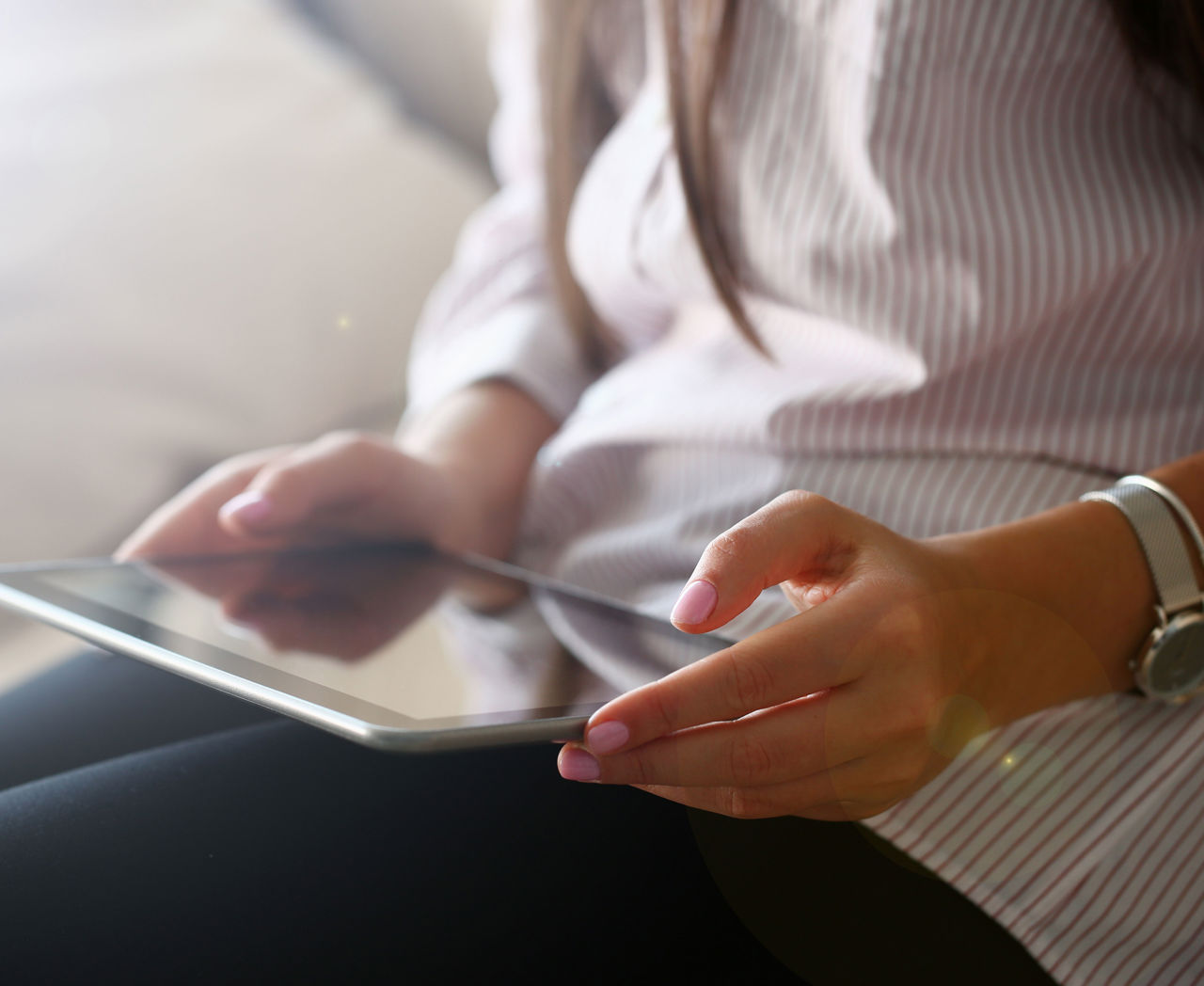 Kvinde der sidder med sin iPad i skødet