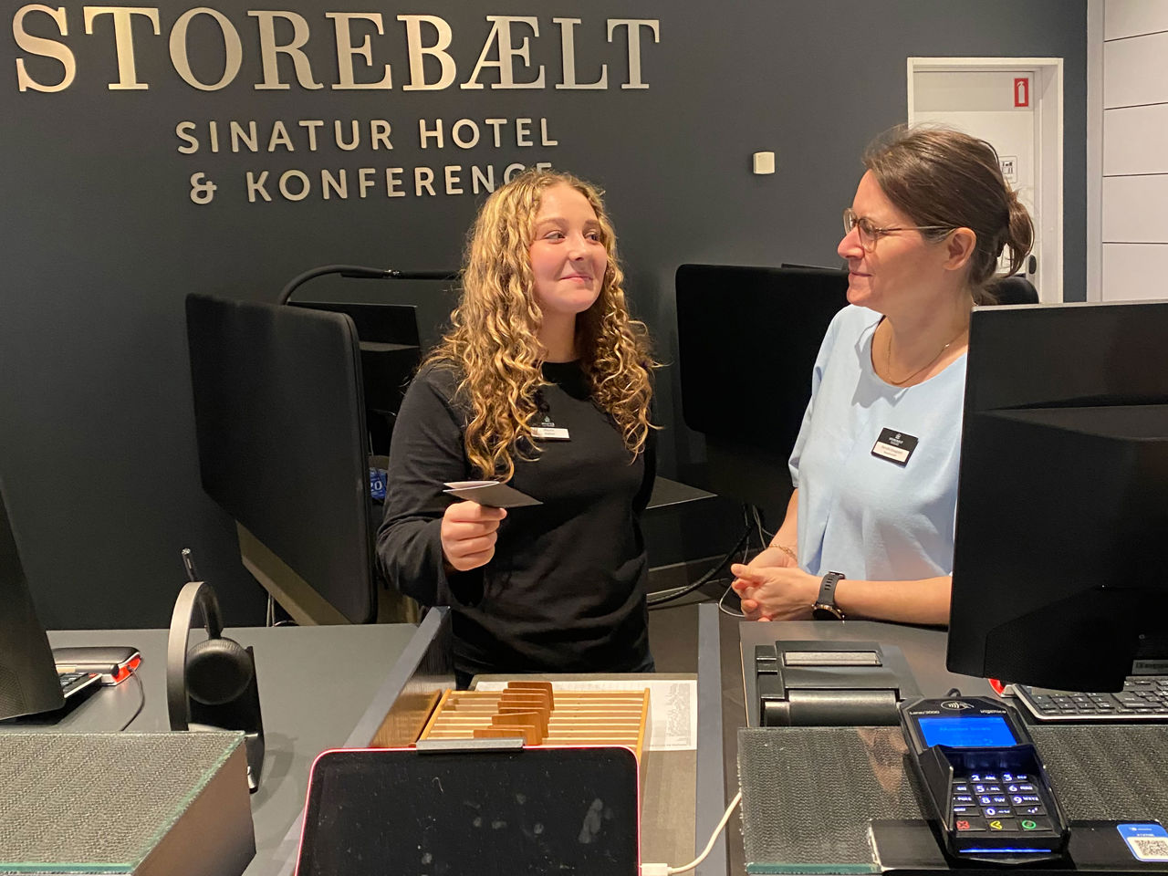 Juniormesterlæreelev lærer at stå i receptionen