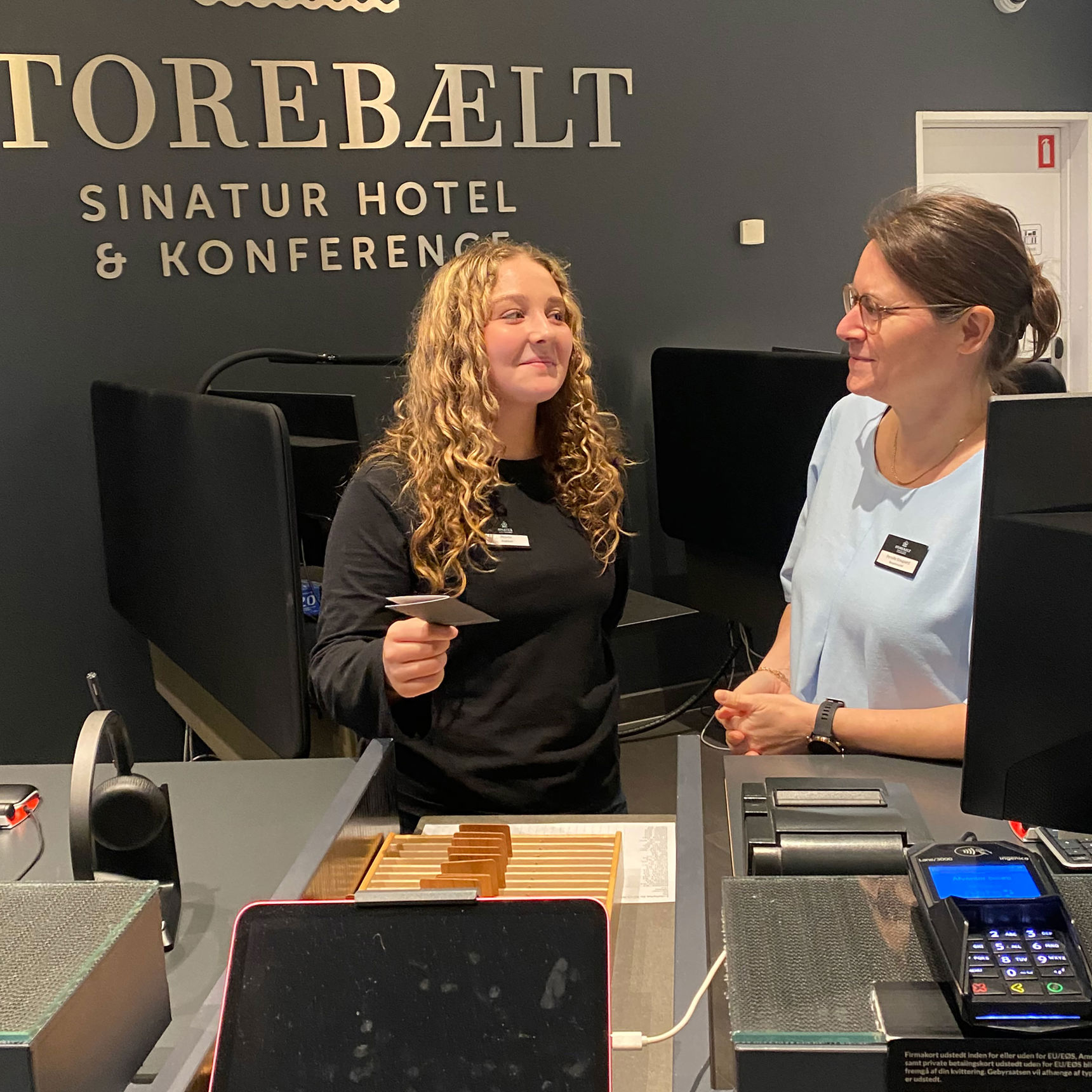 Juniormesterlæreelev lærer at stå i receptionen