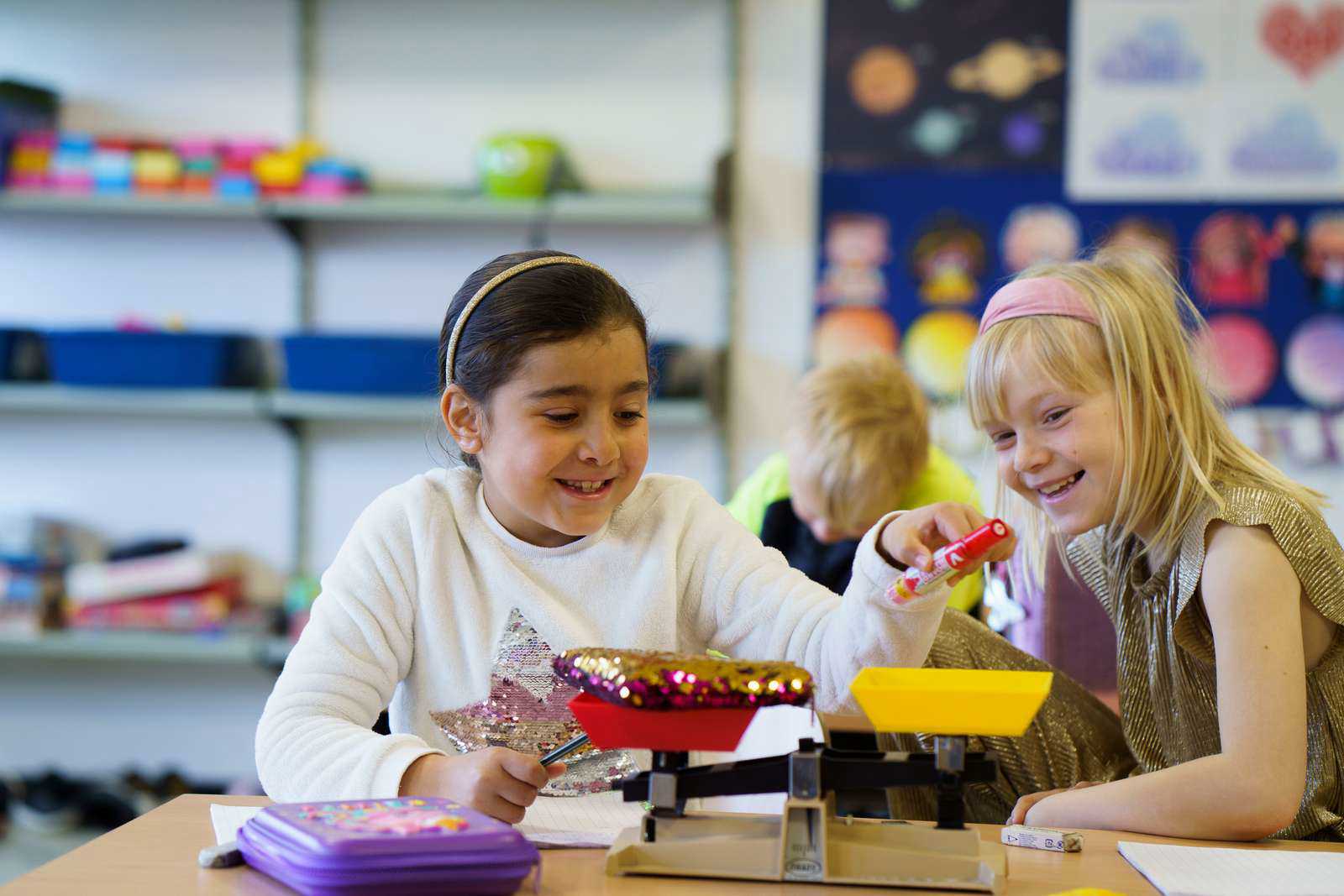 Piger vejer ting i klasselokalet