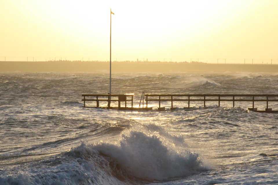 En badebro med høje bølger og skumsprøjt