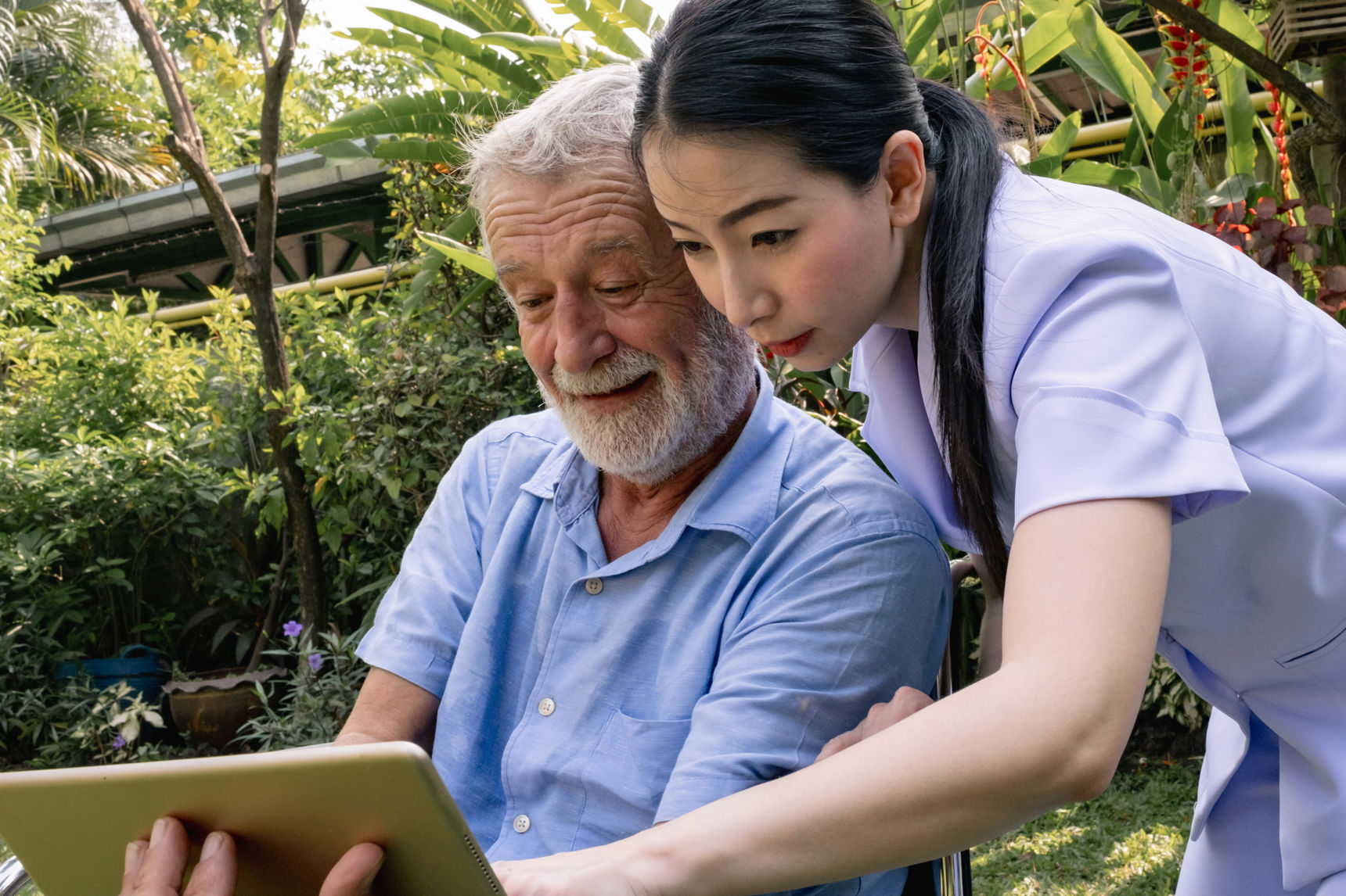 Kvinde med ældre mand der kigger på iPad