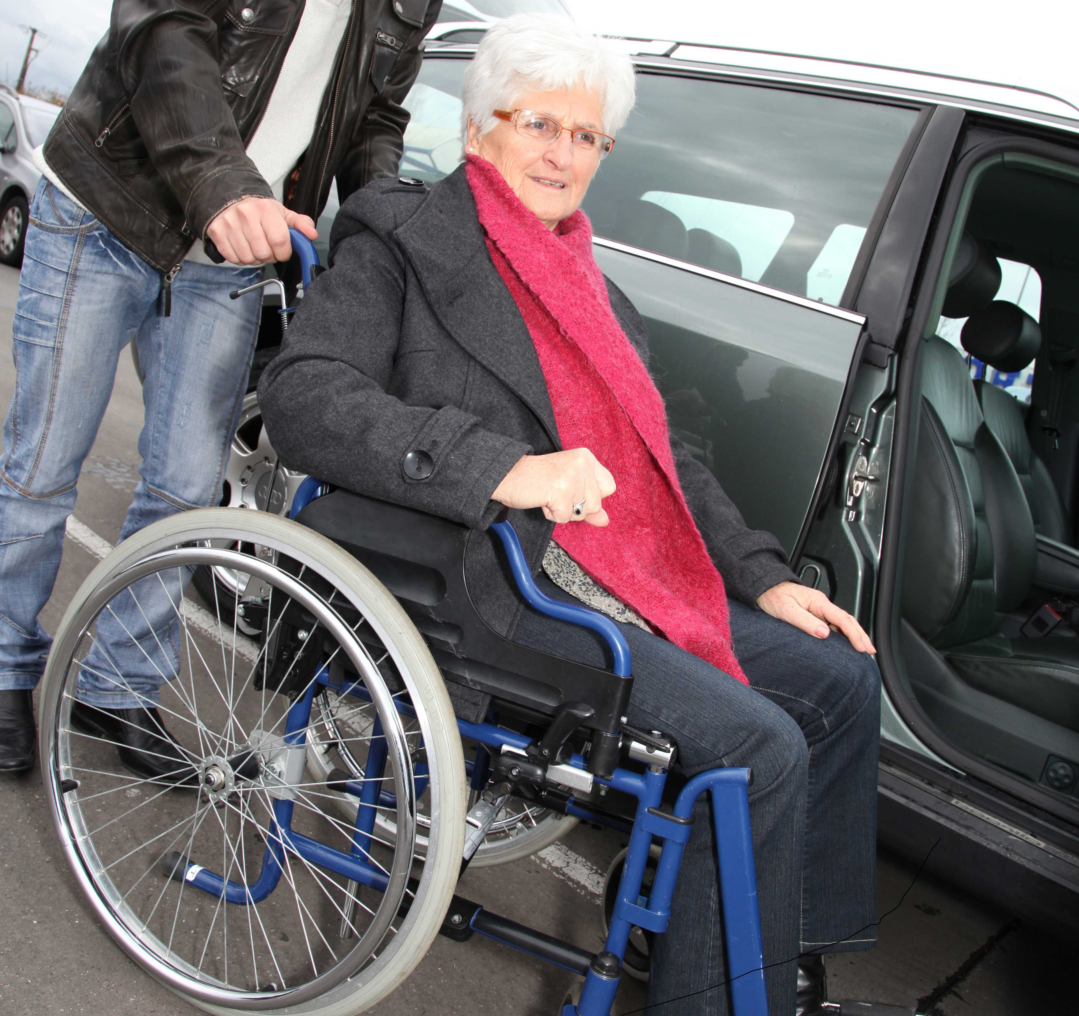 Mand og dame der gør klar til at køre i handicapbil