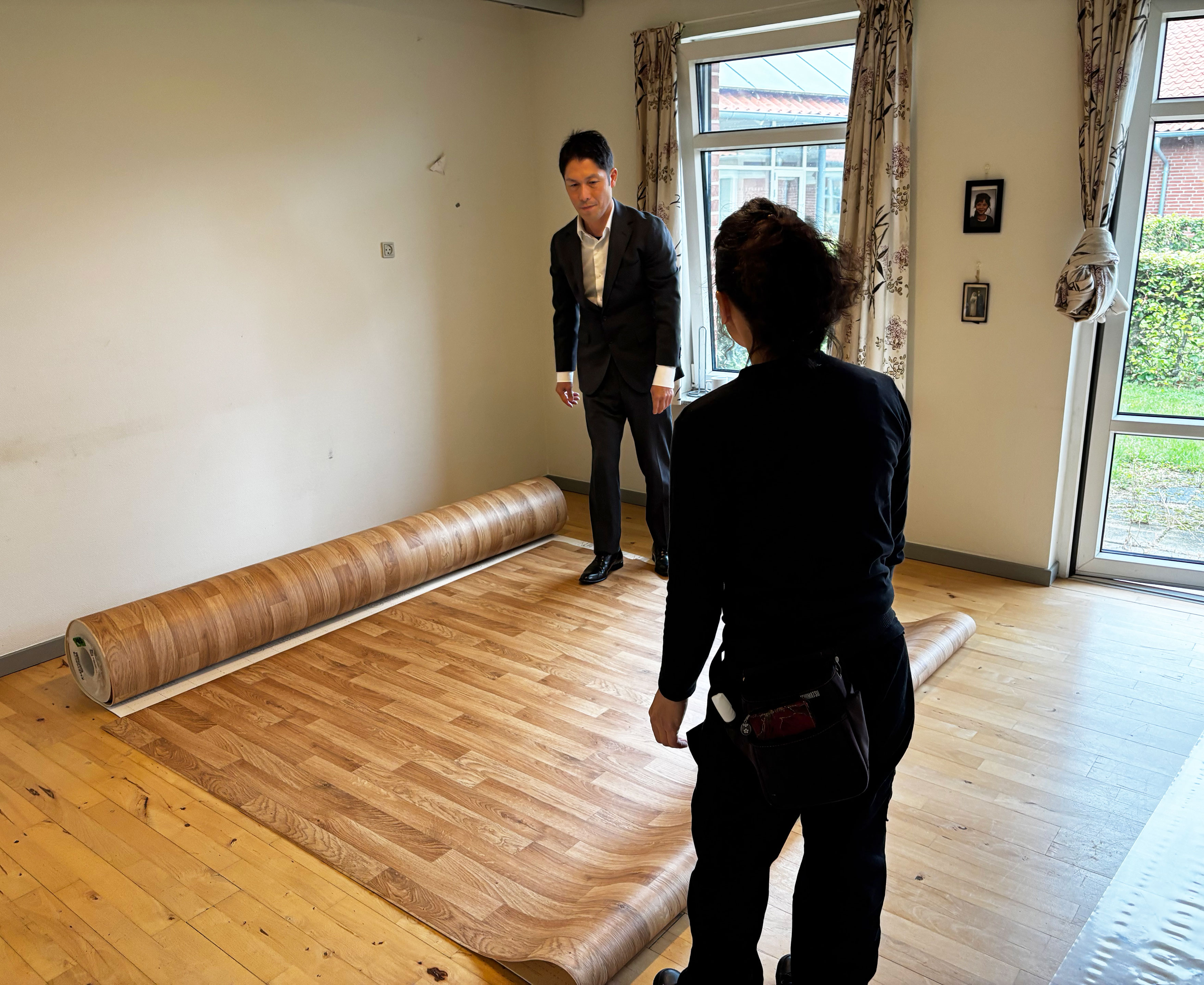 To japanere der lægger fladgulv ud i en lejlighed
