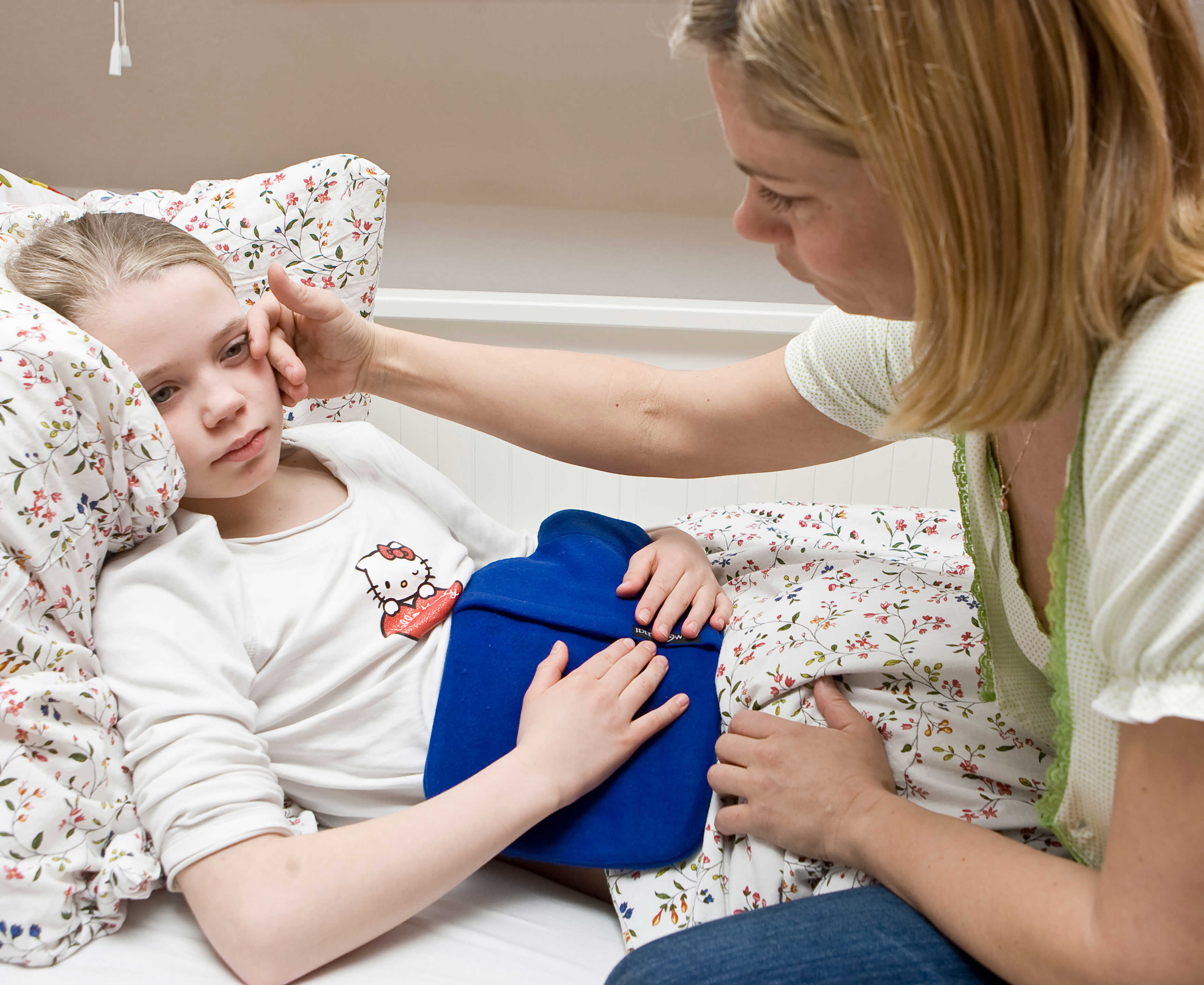 Pige der ligger i sengen med ondt i maven