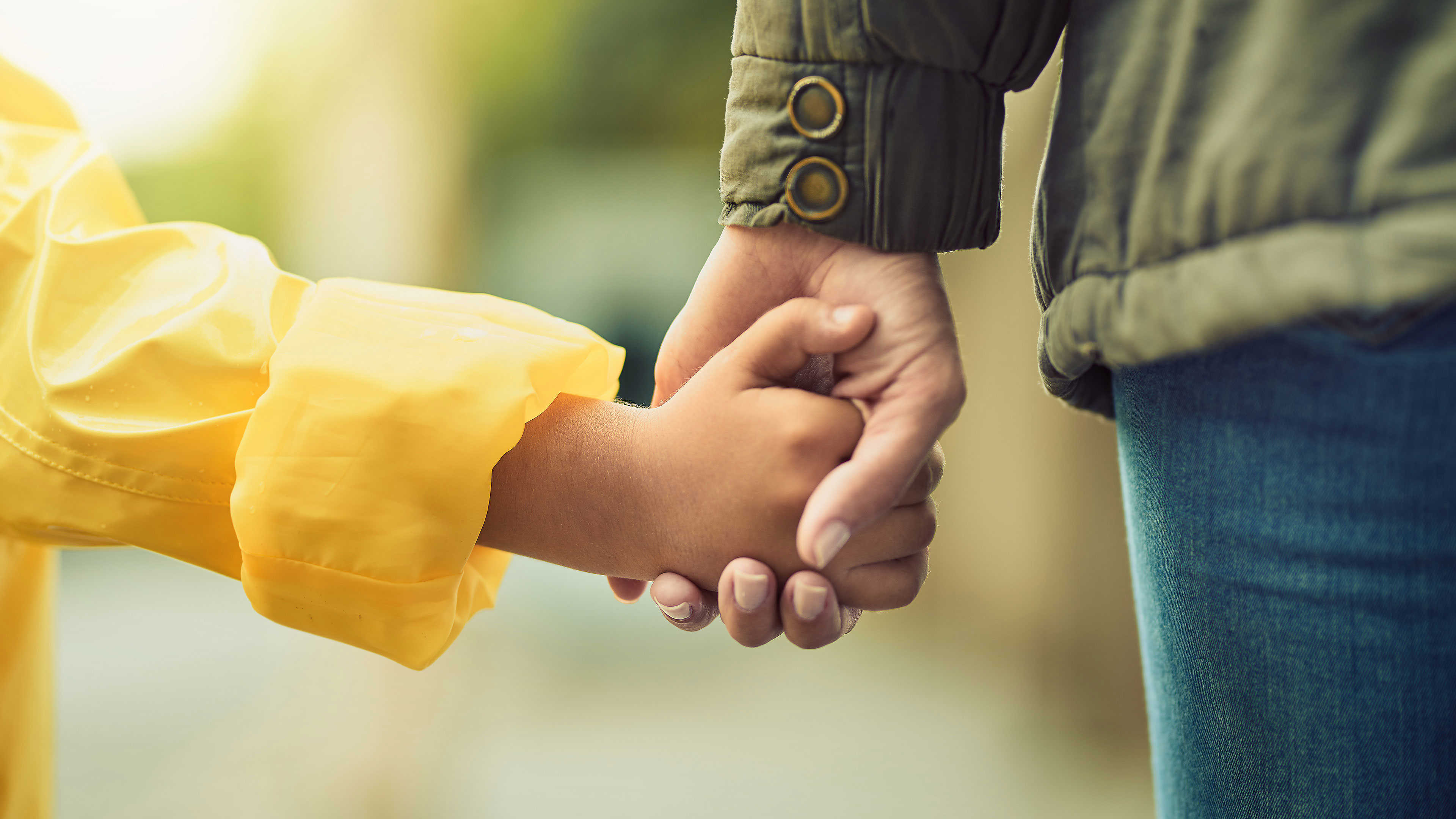 Barn- og voksenhænder der holder hinanden i hånden