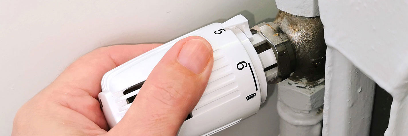 En hånd på en termostat