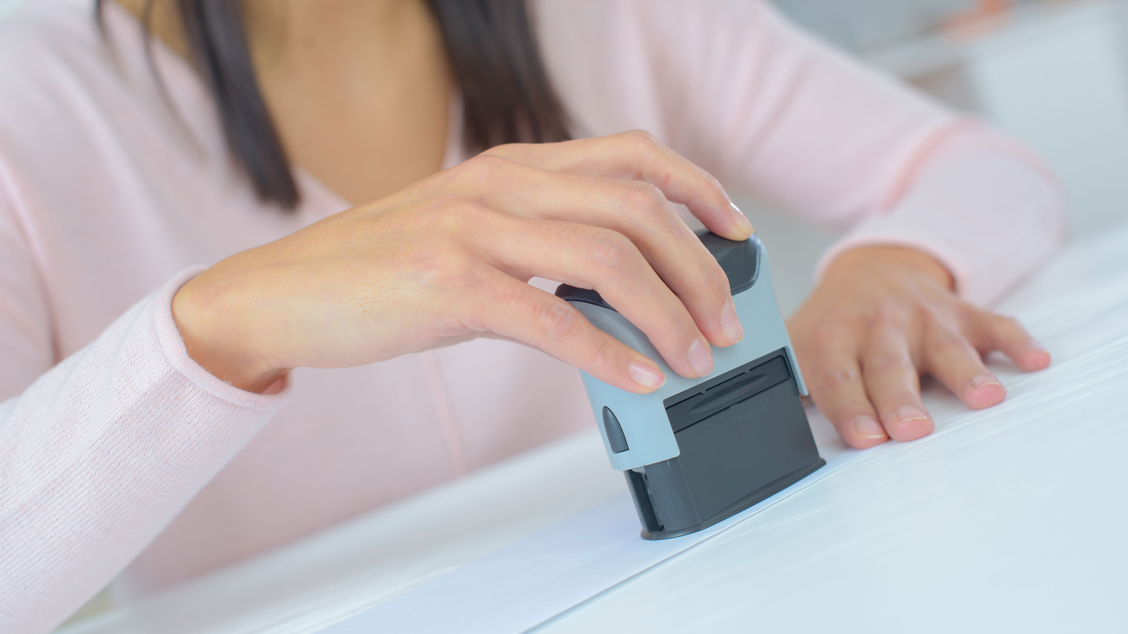 Hånd der sætter et stempel på et stykke papir