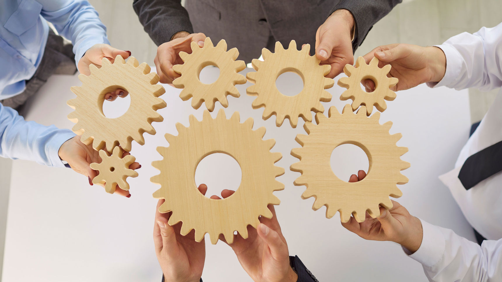 Hænder der holder tandhjul mod hinanden