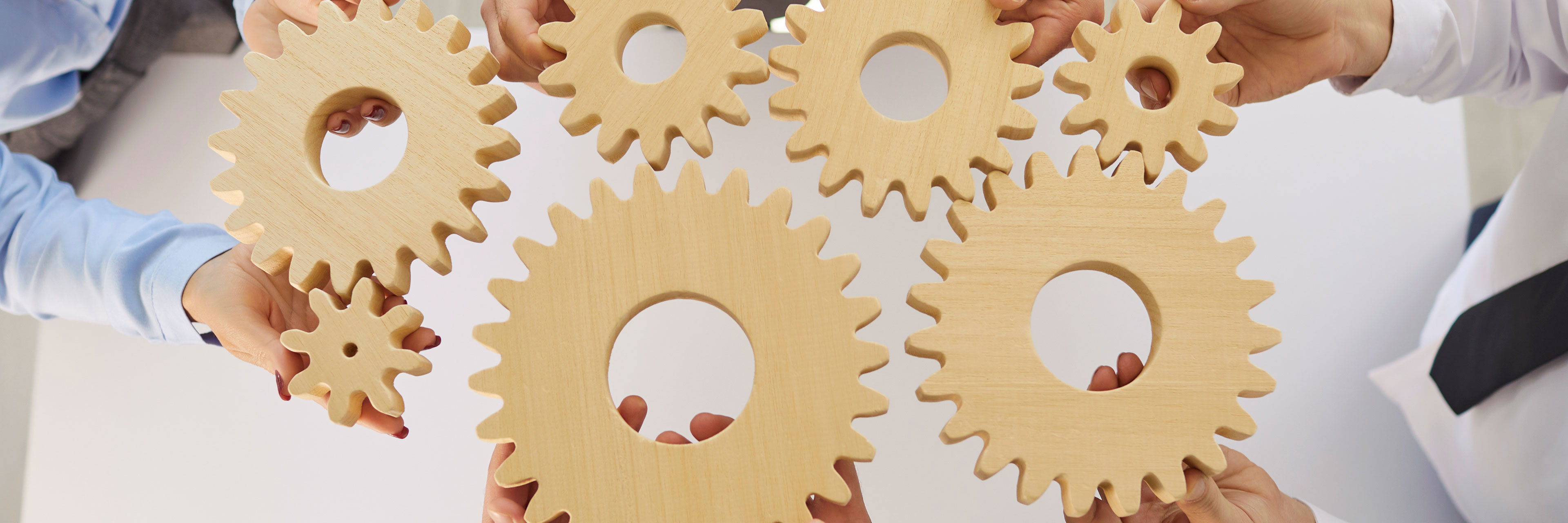 Hænder der holder tandhjul mod hinanden