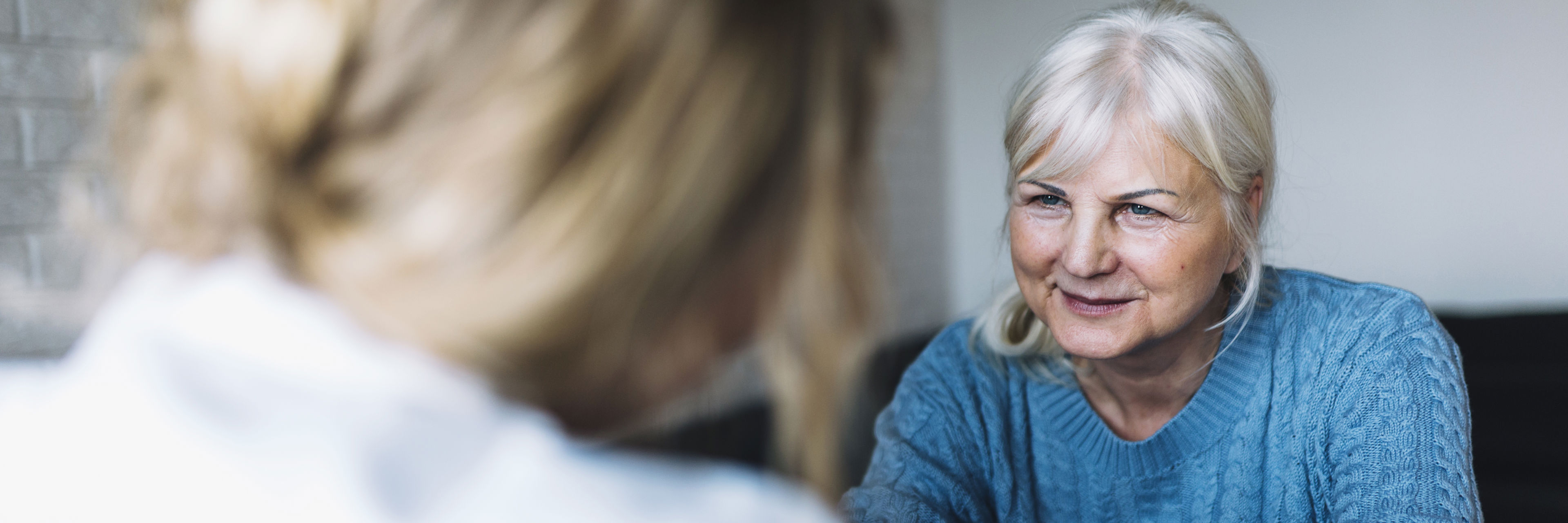 Ældre kvinde samtaler med kvinde