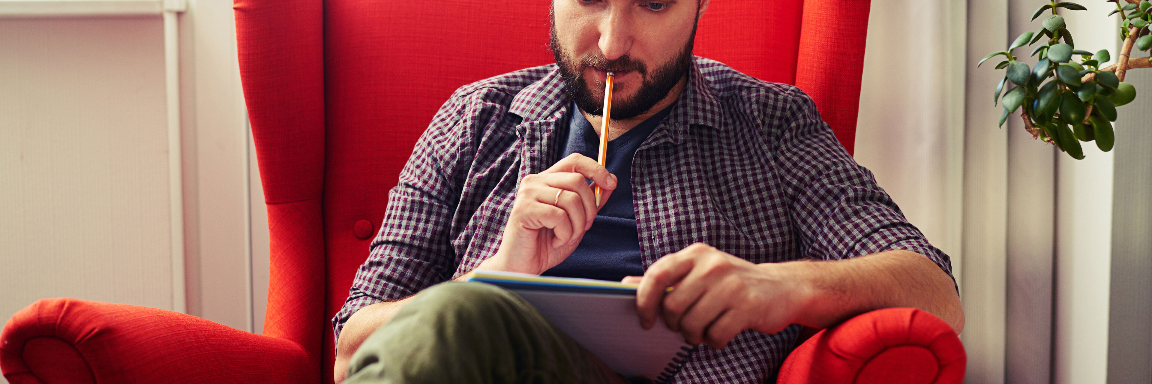 Mand sidder og kigger på en notesblok