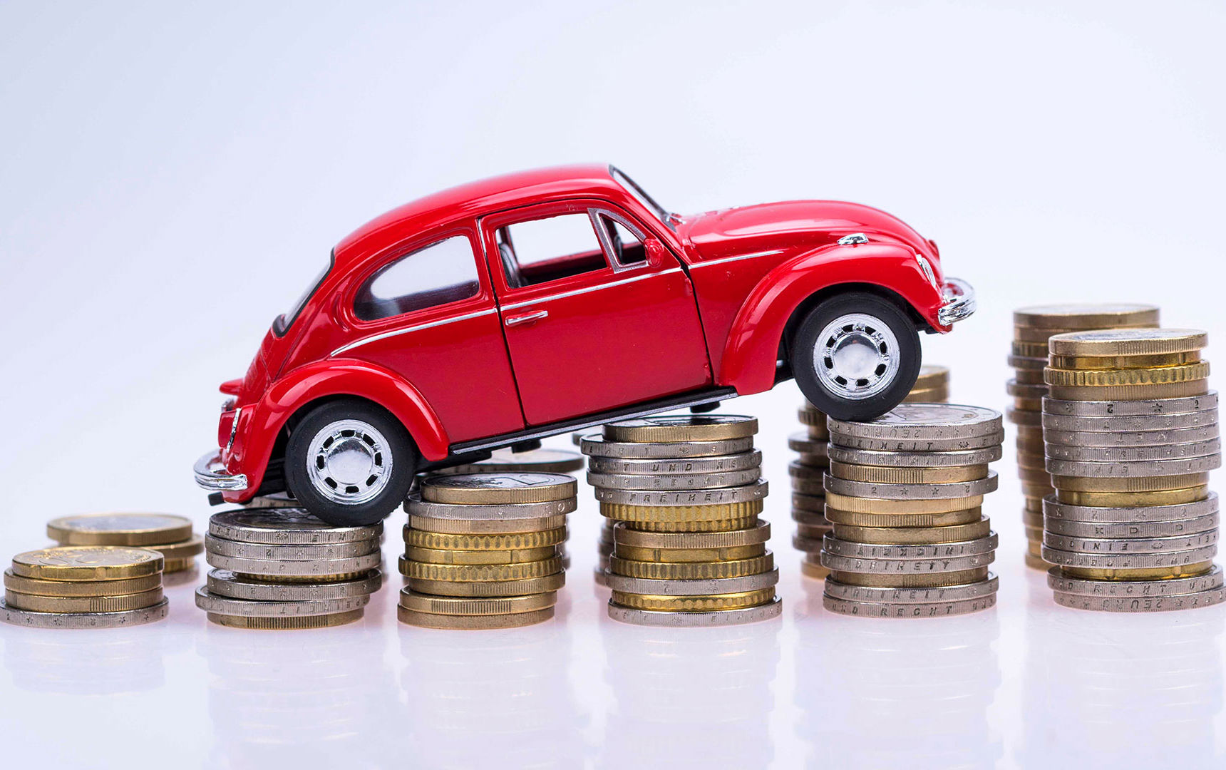 En legetøjsbil sat på en stak mønter