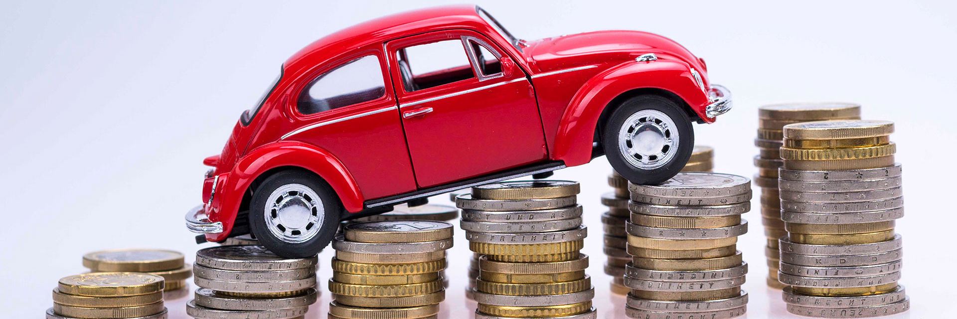 En legetøjsbil sat på en stak mønter