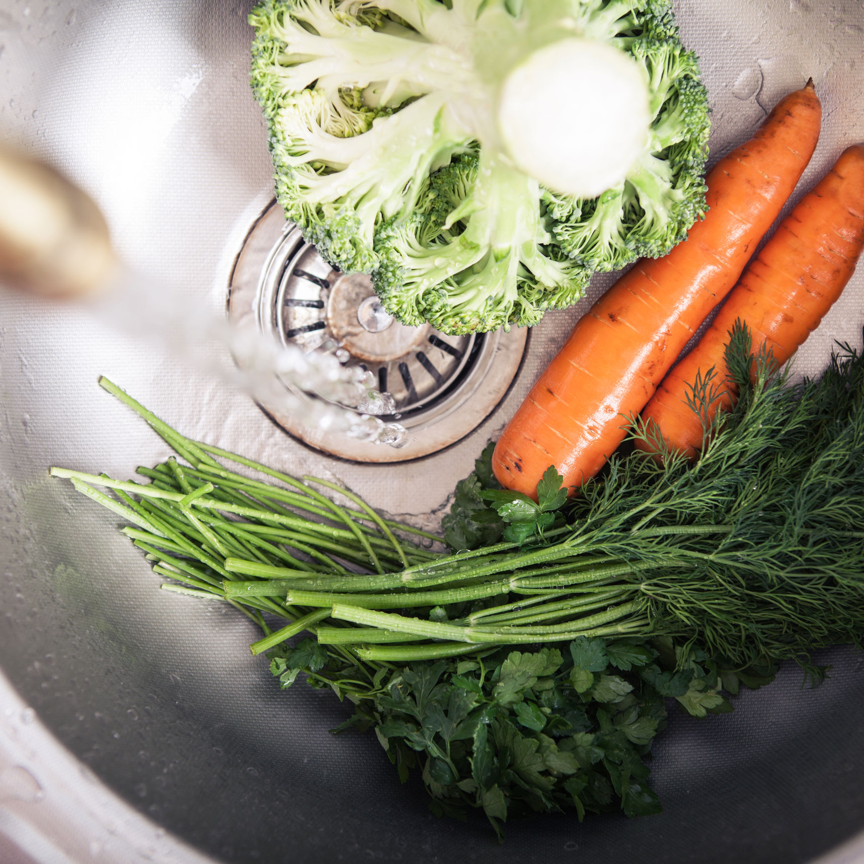 Køkkenvask med grønsager i