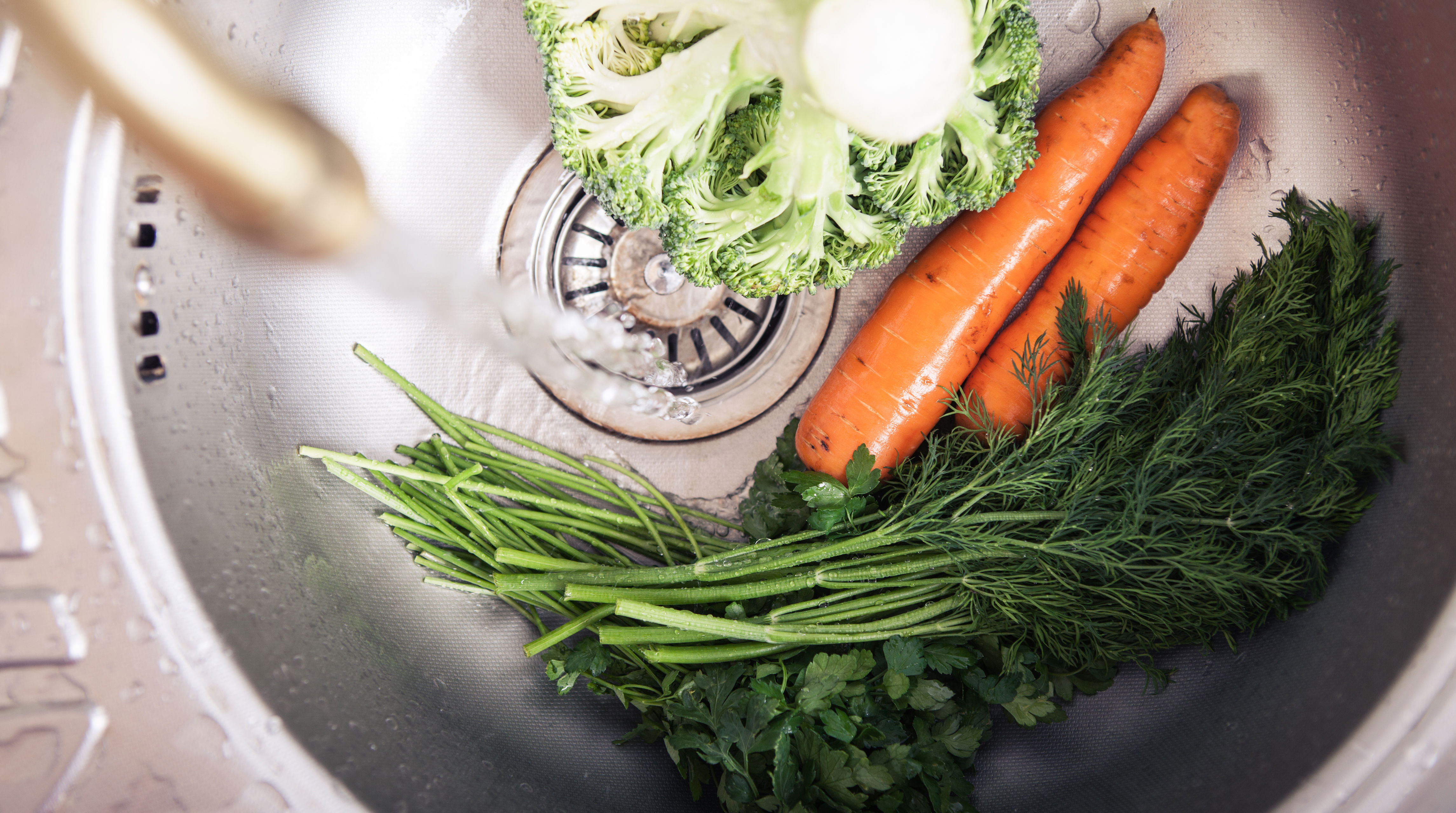 Køkkenvask med grønsager i