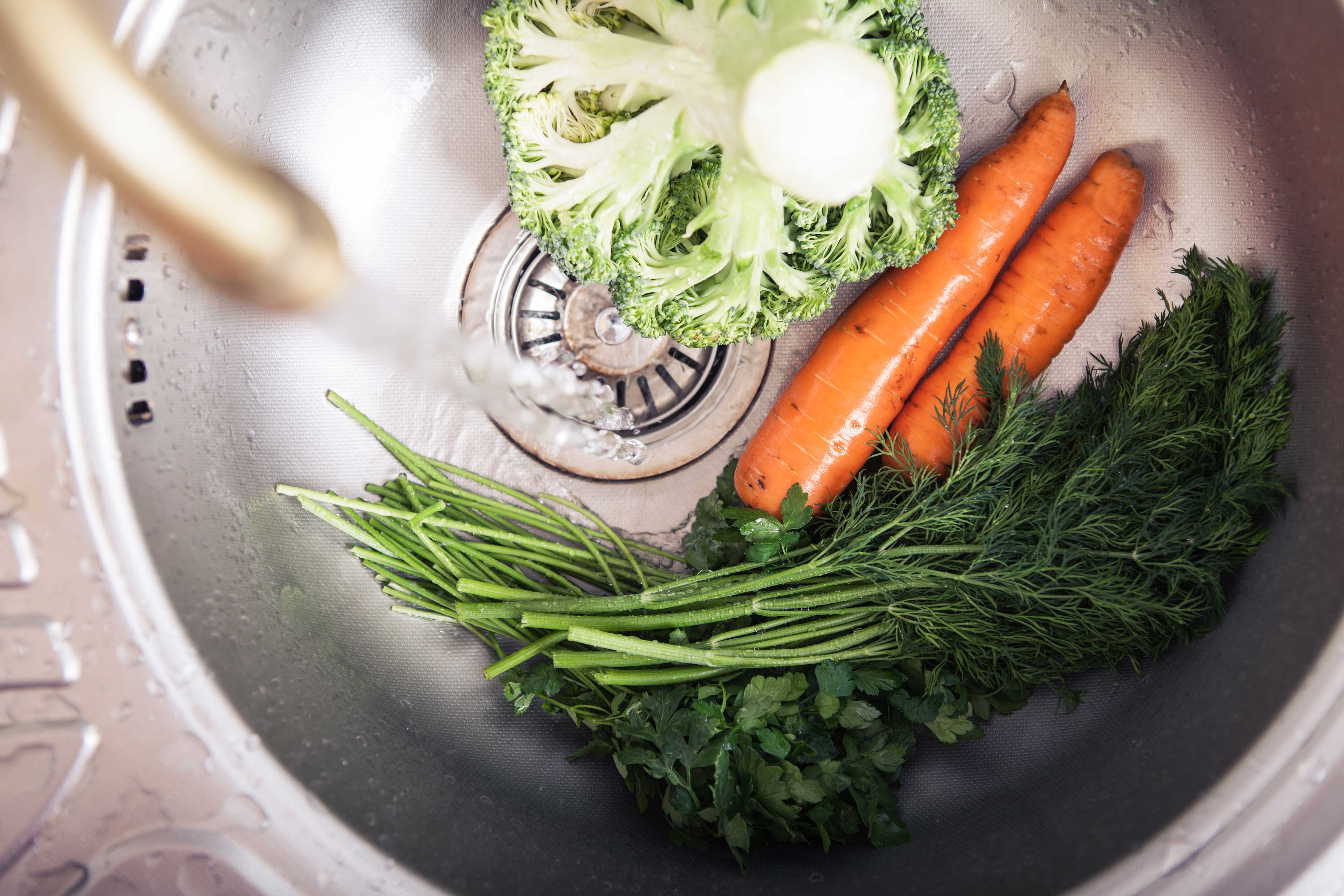 Køkkenvask med grønsager i
