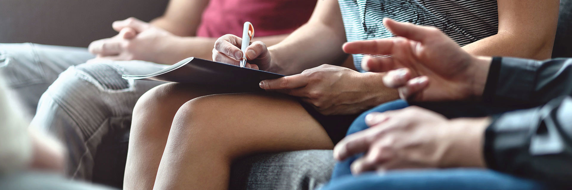 Kroppen af folk der sidder i en sofa