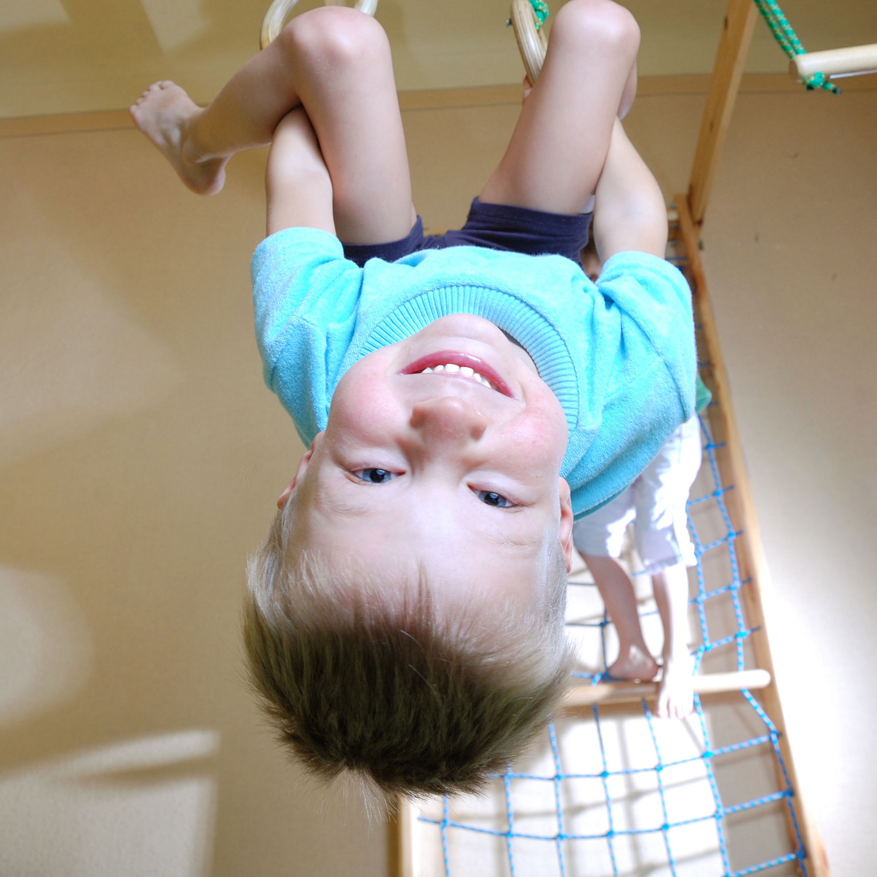 Dreng der sviger sig i ringe i en gymnastiksal