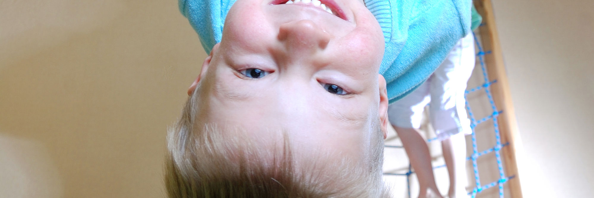 Dreng der sviger sig i ringe i en gymnastiksal