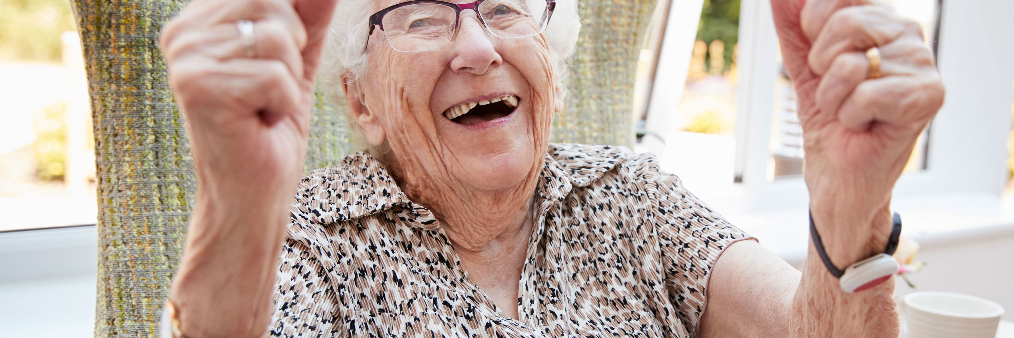 En meget ældre dame der jubler i sin stol