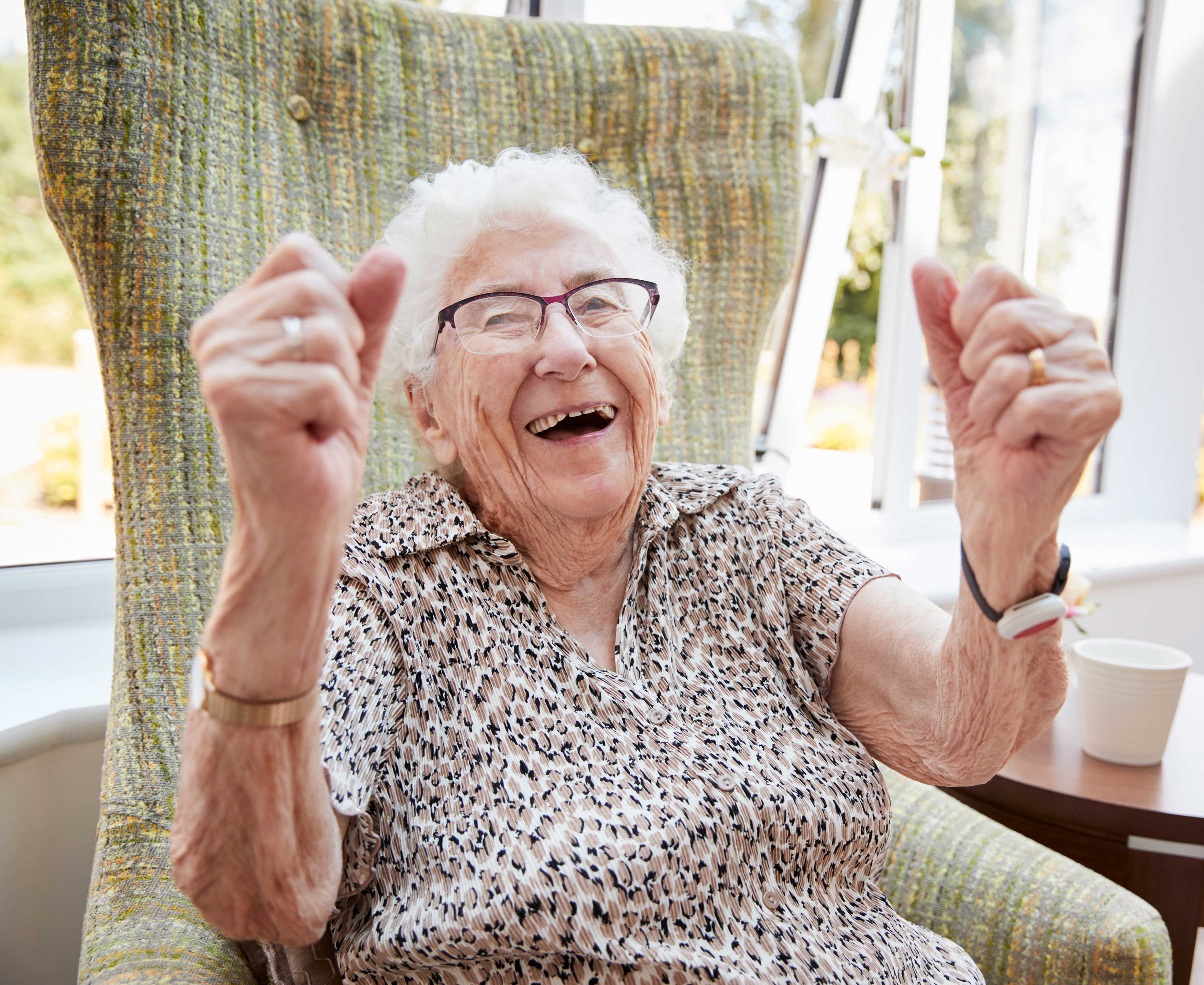 En meget ældre dame der jubler i sin stol