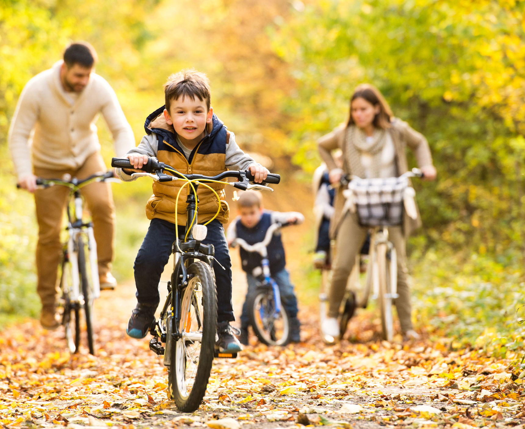 Dreng og hans familie der cykler i skoven