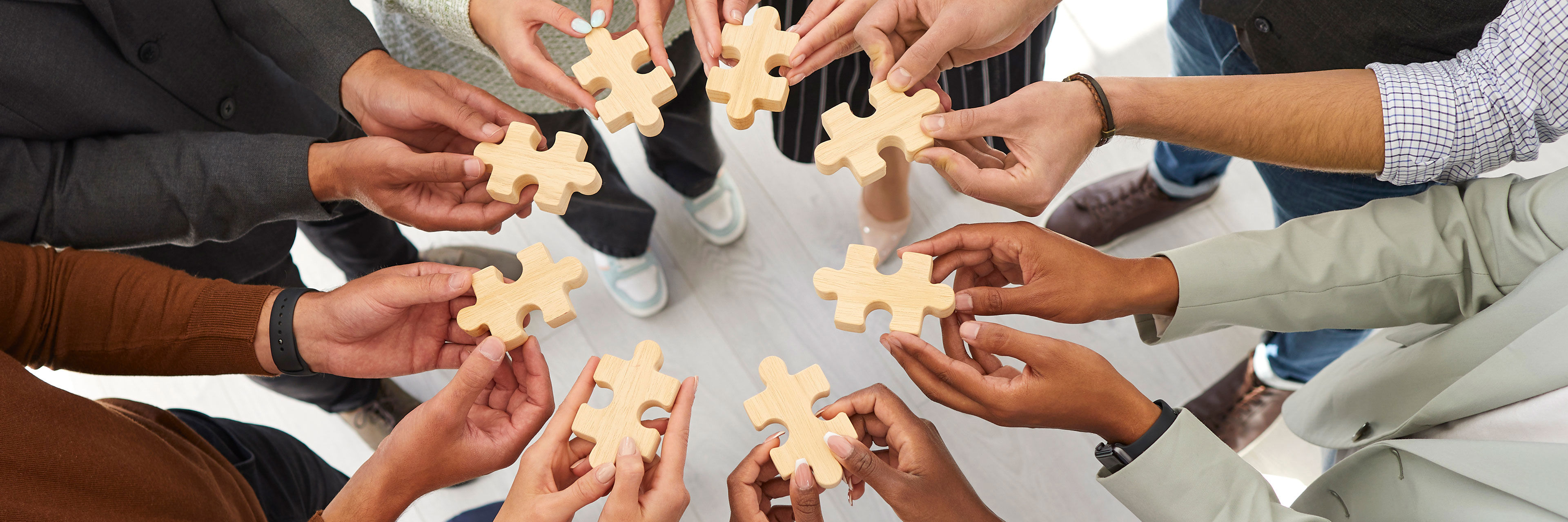 Hænder der hver holder en puslespilsbrik mod hinanden