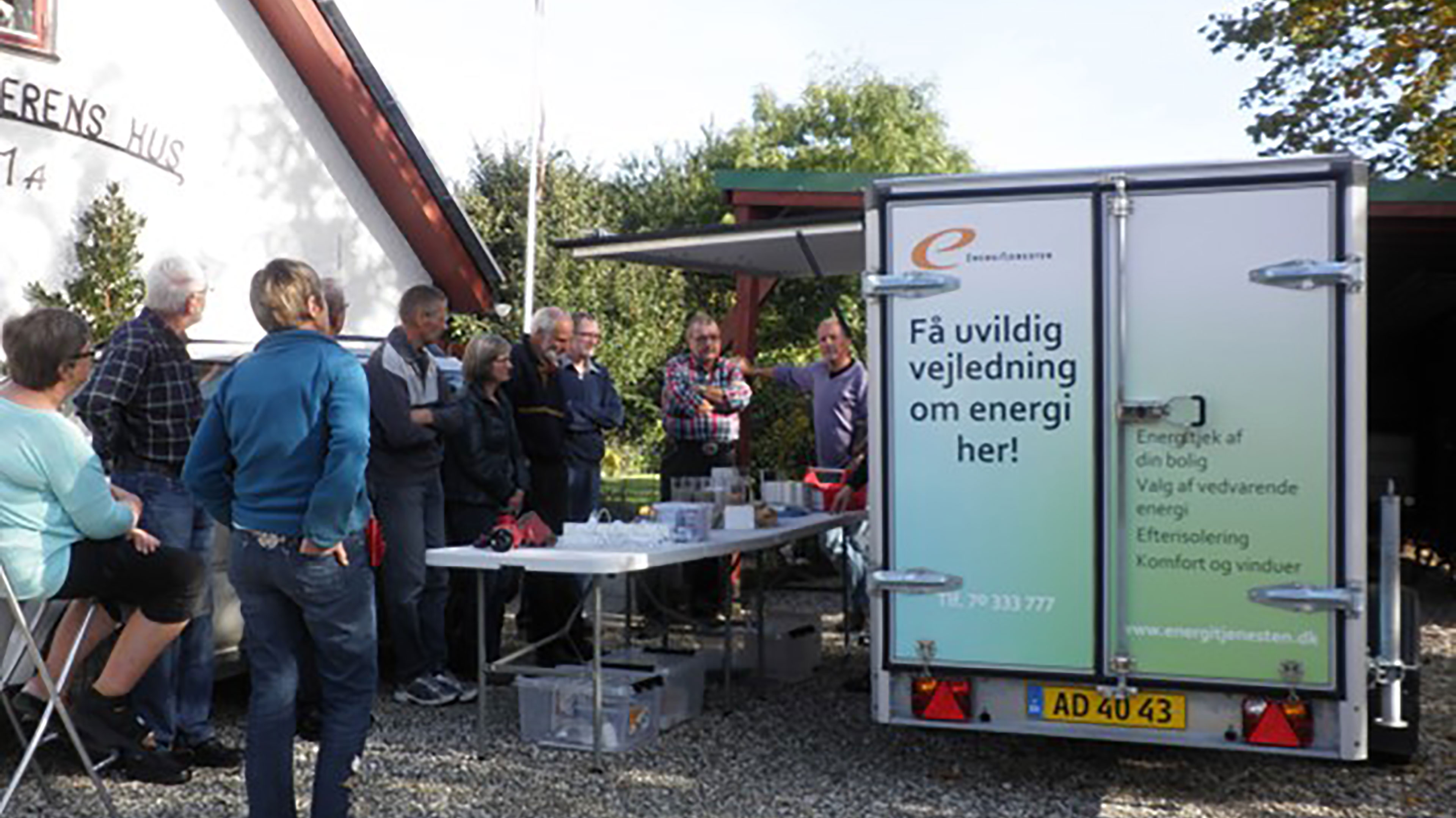 Folk der står udendørs og får vejledning om energi