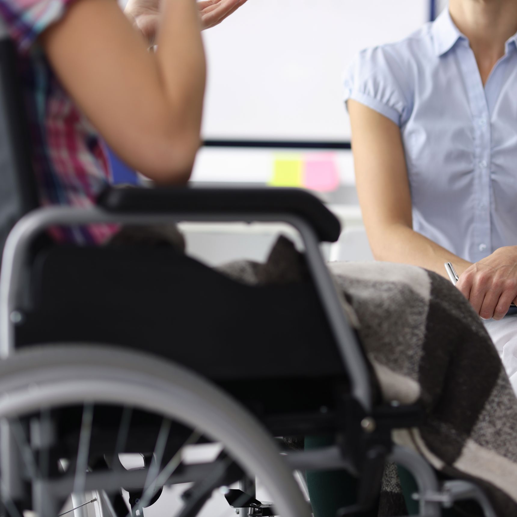 To kvinder i en samtale - den ene i kørestol