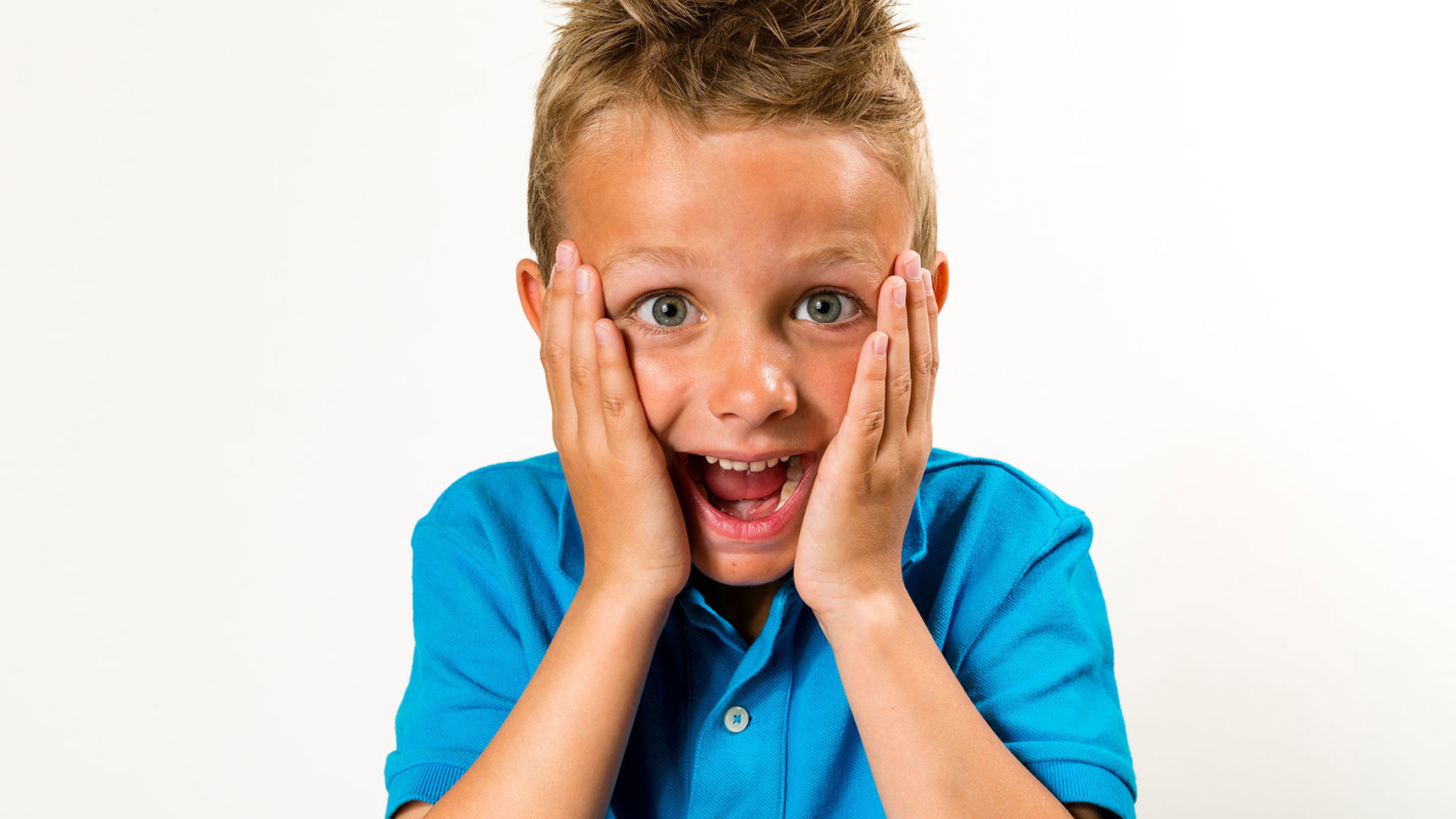 Dreng med åben mund og hænder på kinderne
