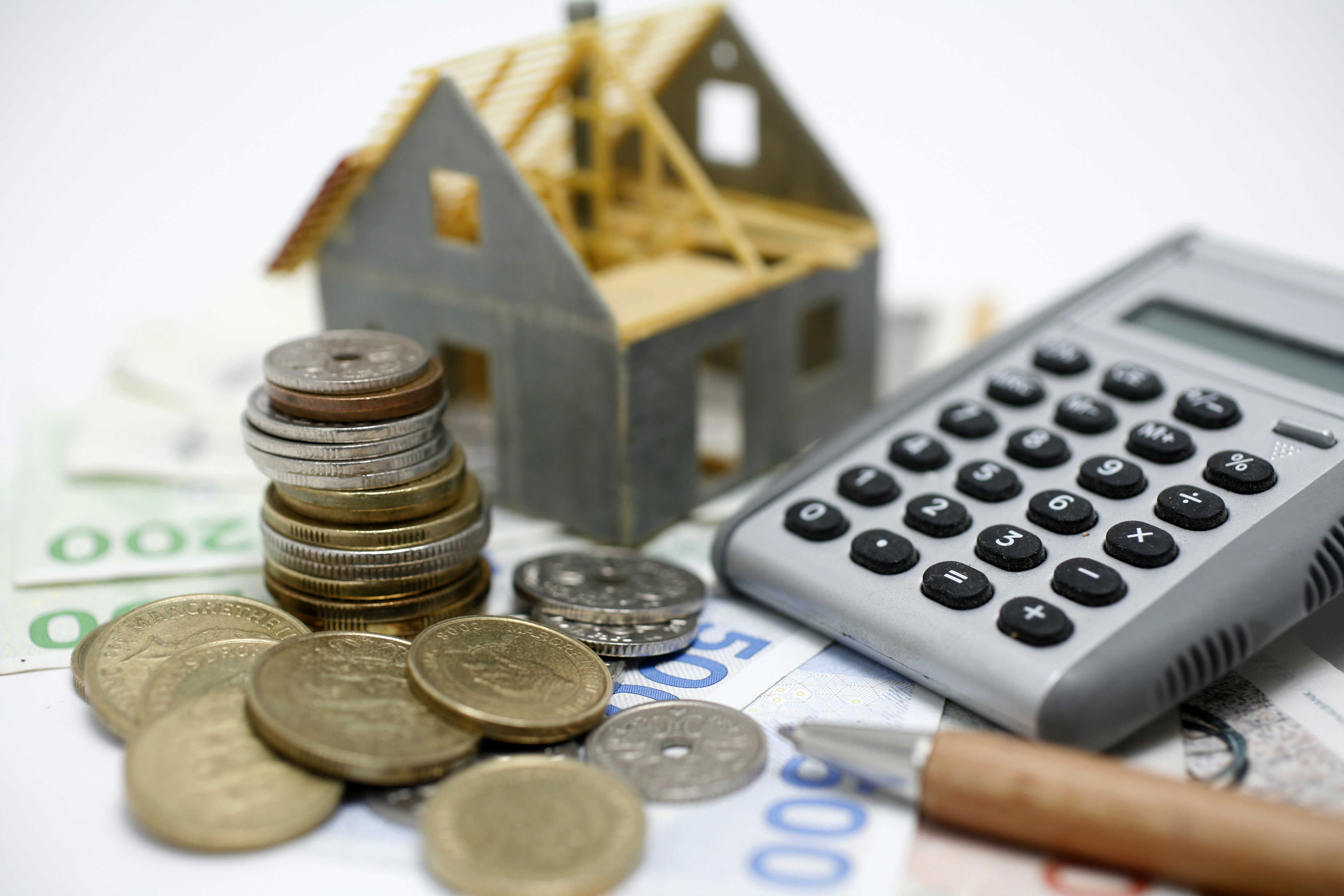 Penge, lommeregner og husfigur