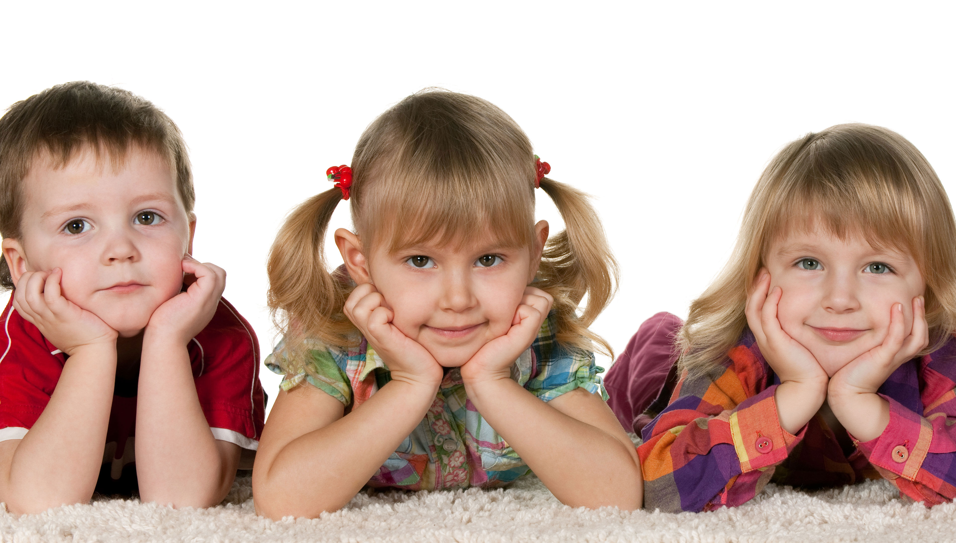 Mindre børn der ligger på maven med hænderne under hovedet