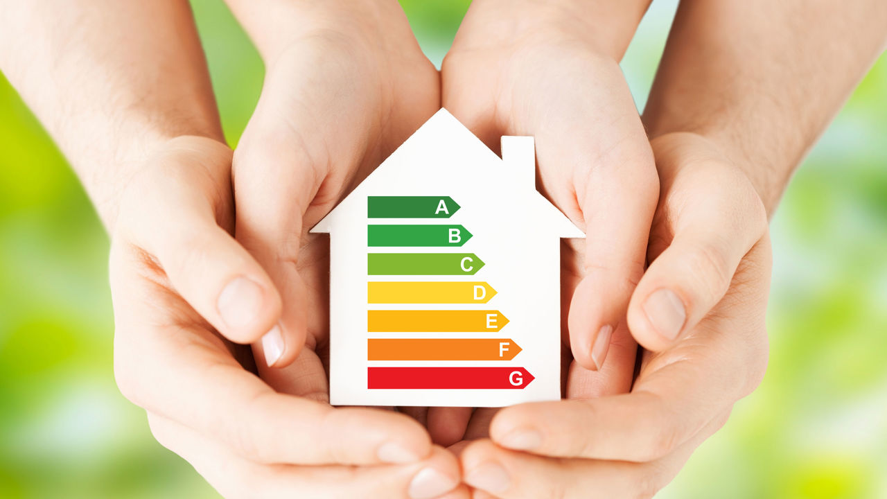 Hænder der holder et paphus, der viser energimærkning